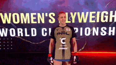 a woman stands in front of a sign that says women 's lyweigh world championship