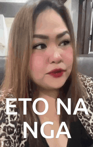 a woman in a leopard print shirt has the words " eto na nga " written on her face