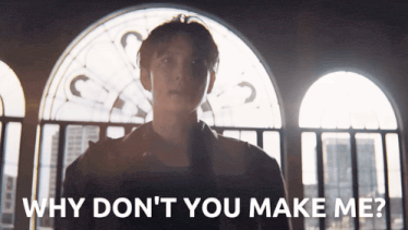 a man standing in front of a window with the words " why don 't you make me "