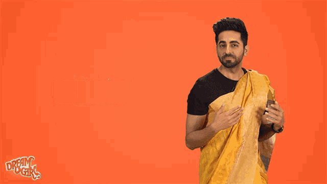 a man is wearing a yellow saree and the word haww is on the orange background behind him