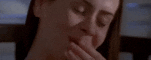 a woman is covering her mouth with her hand while smiling .