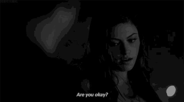 a woman is talking to a man in a black and white photo and asking if he is okay .