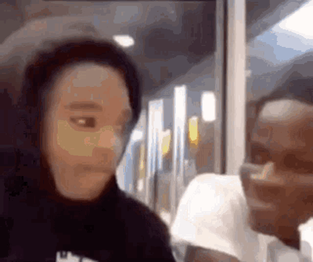 a man and a woman are sitting next to each other on a bus and looking at the camera .