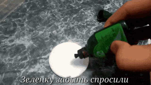 a person is pouring a green liquid into a cotton pad