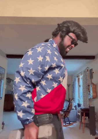 a man with a beard wearing an american flag jacket and sunglasses