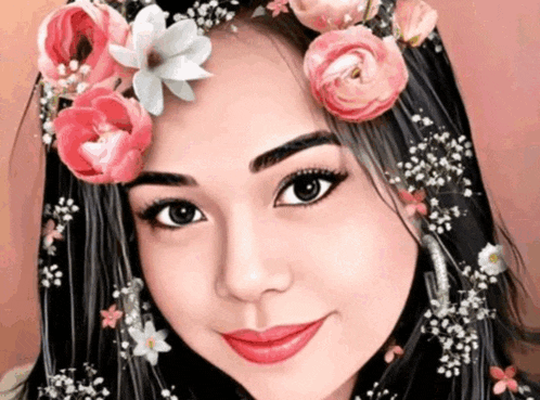 a woman with flowers in her hair is smiling