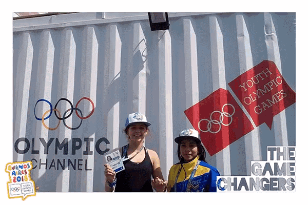 two women stand in front of a wall that says youth olympic games