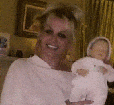a woman in a white shirt is holding a baby doll