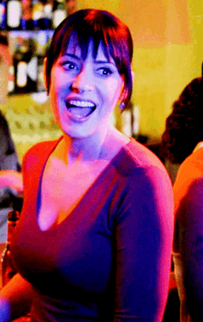 a woman in a purple shirt is smiling with her mouth wide open