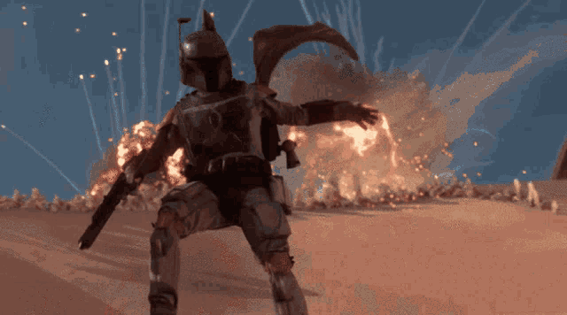 a man in a helmet is holding a gun in front of a large explosion