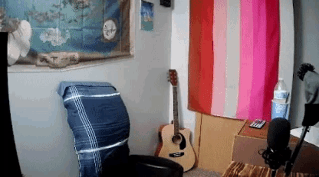a guitar is sitting in front of a pink and white striped flag