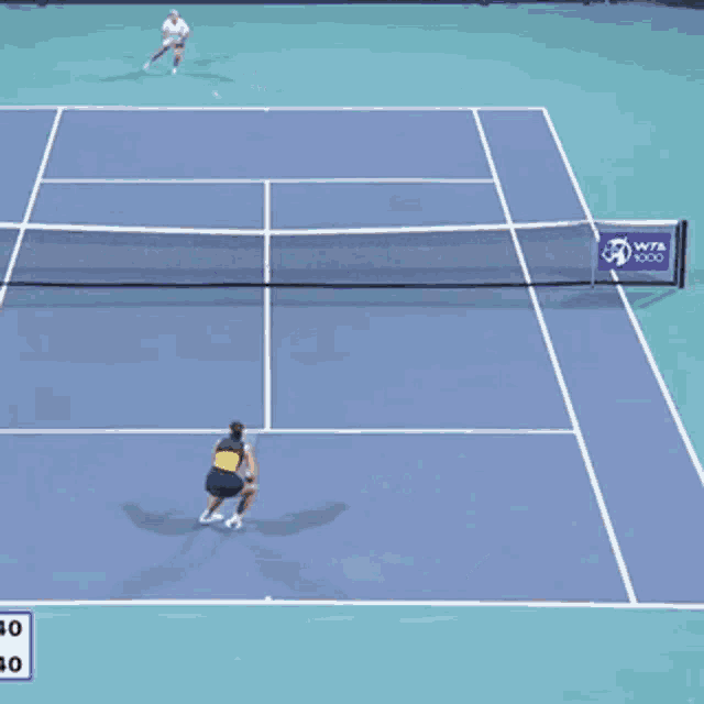 a tennis game is being played on a court with a wta logo