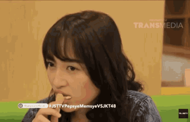 a woman is eating a french fries with a transmedia logo on the bottom