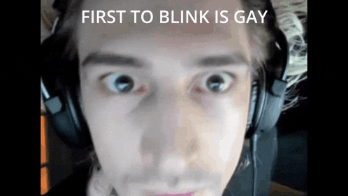 a close up of a person 's face with the words first to blink is gay written above it