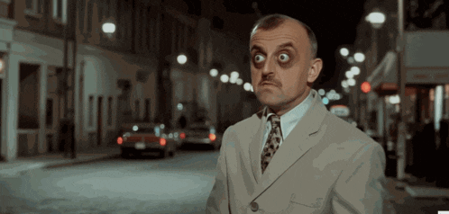a man in a suit and tie is standing on a street