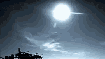 the sun is shining brightly in the sky above a military helicopter