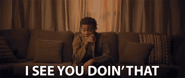 a man sitting on a couch with the words " i see you doin ' that "