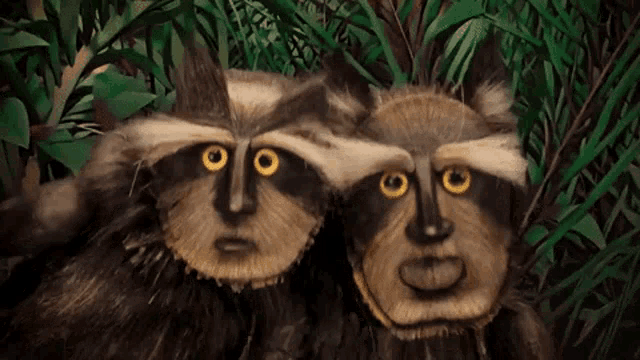 two raccoons with faces painted on them are standing next to each other