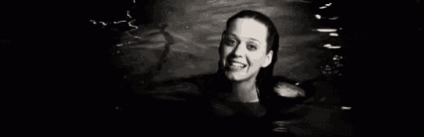 a black and white photo of a woman swimming in a pool .