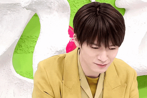a young man in a yellow jacket looks down