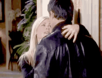 a man and a woman are hugging each other in a room .