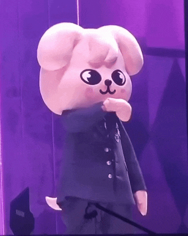 a stuffed animal is standing on a stage with a microphone in front of it .