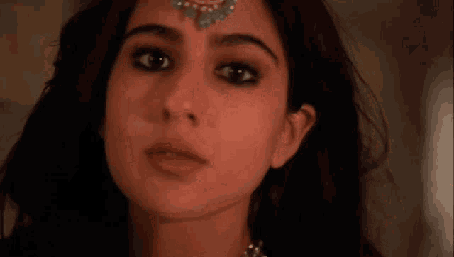 a close up of a woman 's face with a bindi on her forehead