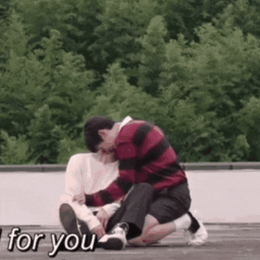 a man and a woman are sitting on the ground .