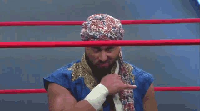 a man wearing a turban and a blue shirt is in a boxing ring