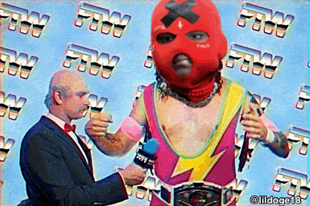a man in a tuxedo is talking to a wrestler in a pink and yellow outfit