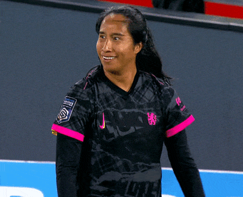 a female soccer player wearing a black and pink jersey with the word soccer on it