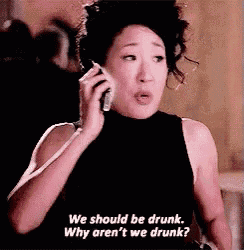 a woman is talking on a cell phone and says we should be drunk why aren 't we drunk