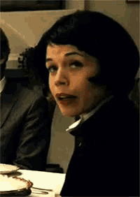 a woman sitting at a table with a cake on it