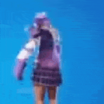 a blurry picture of a woman in a purple outfit standing in front of a blue sky .
