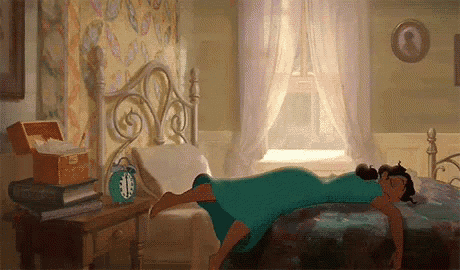 a woman in a blue dress is laying on a bed in a bedroom with an alarm clock on the nightstand .