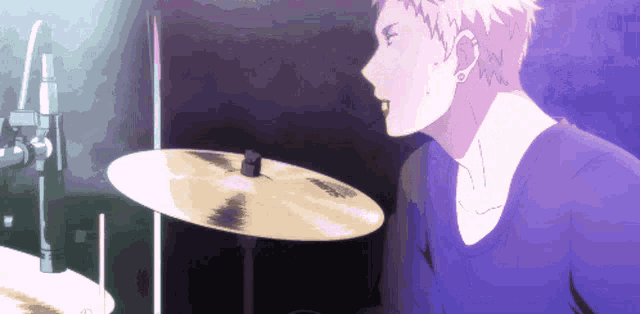 a man in a blue shirt is playing a cymbal with sabian on it