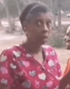 a woman in a pink shirt with hearts on it is talking to another woman