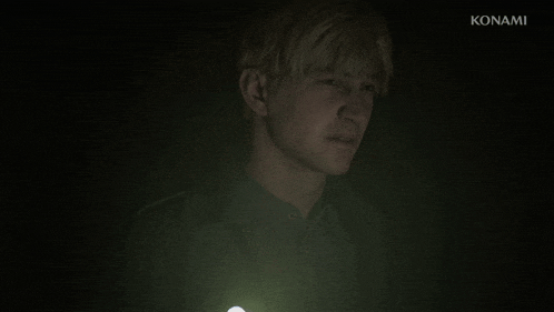 a man in a dark room with a konami logo in the corner