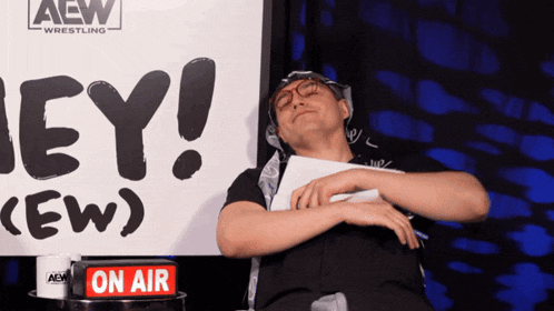 a man sleeping in front of a sign that says hey