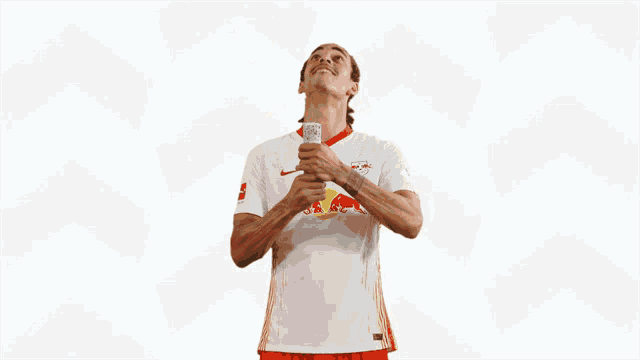 a soccer player wearing a white jersey with a red bull on it is surrounded by confetti