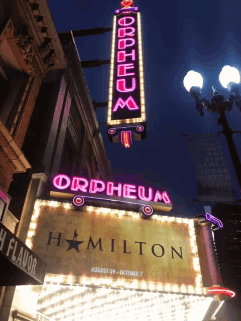 an orpheum sign is lit up at night and says hamilton
