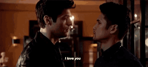 two men are standing next to each other and looking at each other .