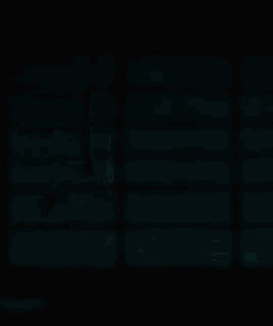 a girl with long hair and a tie is sitting in the dark