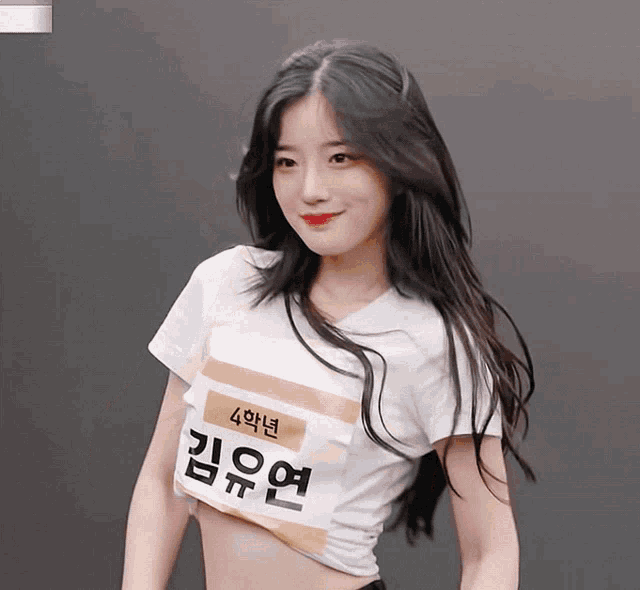 a girl wearing a white crop top with a name tag that says 4