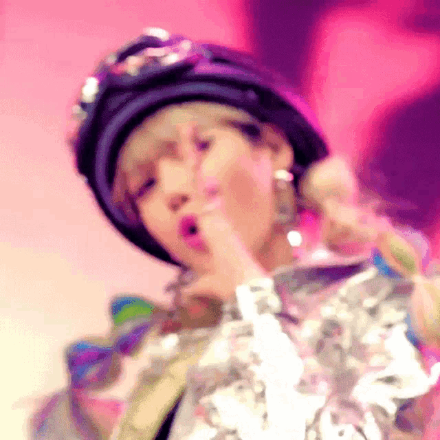 a woman wearing a hat and goggles is making a gesture with her finger