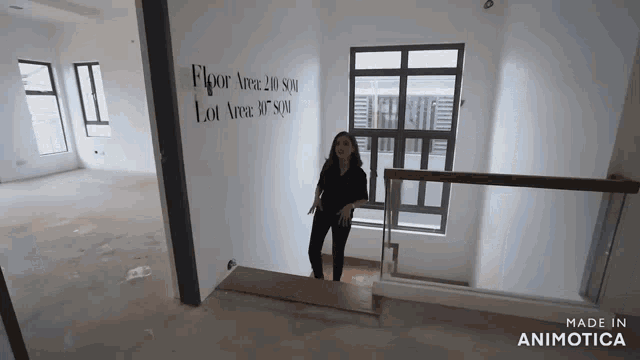 a woman is standing on a set of stairs in an empty room with a sign that says floor area 20 sqm