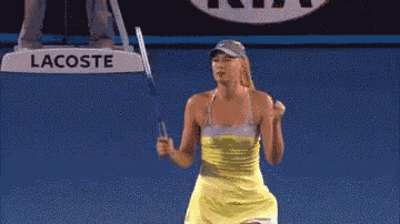 a woman is holding a tennis racquet in front of a sign that says lacoste