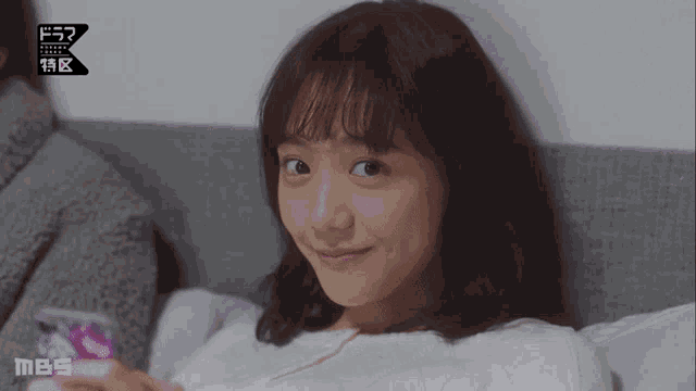a woman laying on a bed with mbs written on the bottom left