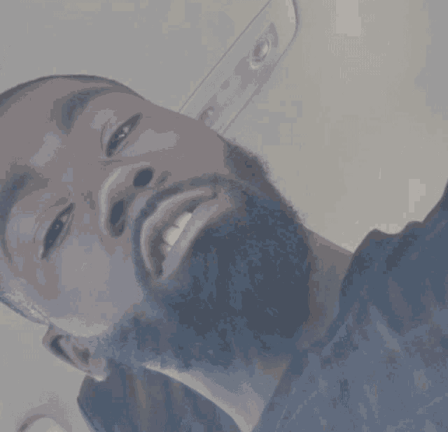 a man with a beard is smiling and looking up at the camera