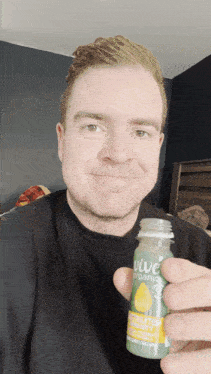 a man is holding up a bottle of vive organic juice